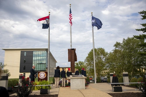 Group of students giving presentation in front of flags.